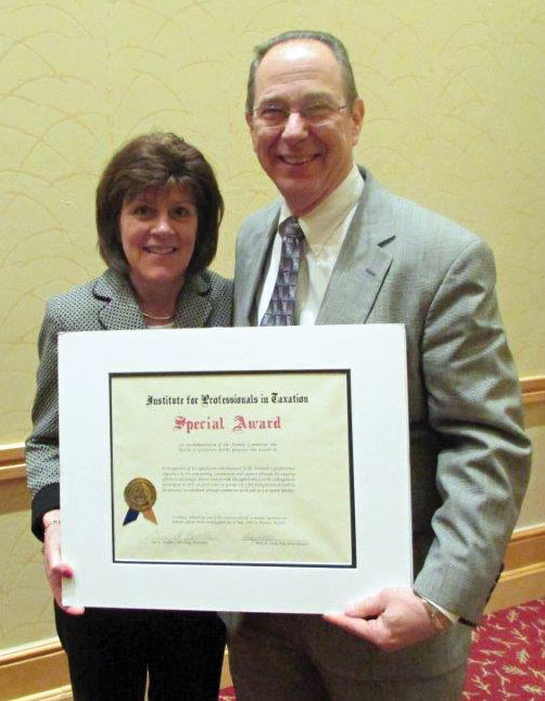 IPT President Arlene Klika presents tax attorney Stewart M. Weintraub with the Special Award from the Institute for Professionals in Taxation on July 1, 2014. The award recognizes Weintraub’s many years of leadership in service to the organization.